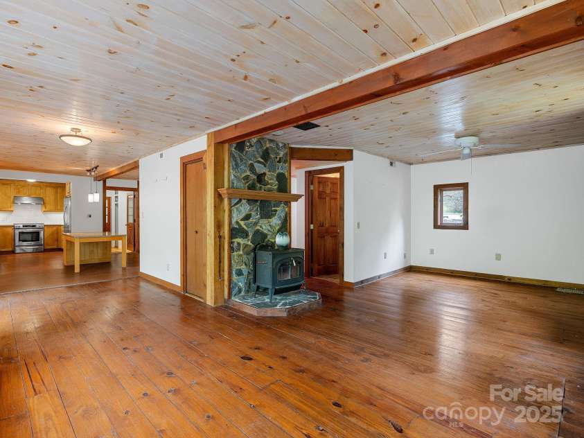 241 Pinefield Drive, Tryon, NC 28782.  MLS# CAR4250675, YatesRealty ID 7781. Family room looking toward kitchen and living room