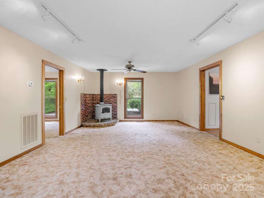 241 Pinefield Drive, Tryon, NC 28782.  MLS# CAR4250675, YatesRealty ID 7781. Great room with wood stove