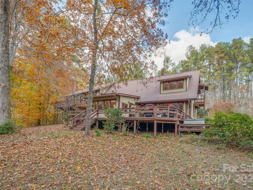 241 Pinefield Drive, Tryon, NC 28782.  MLS# CAR4250675, YatesRealty ID 7781. Rear view of the house in the fall