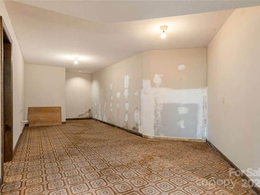 120 Pinewood Circle, Laurel Park, NC 28739.  MLS# CAR4187518, YatesRealty ID 7811. Downstairs flex space, hallway to bedroom and family room