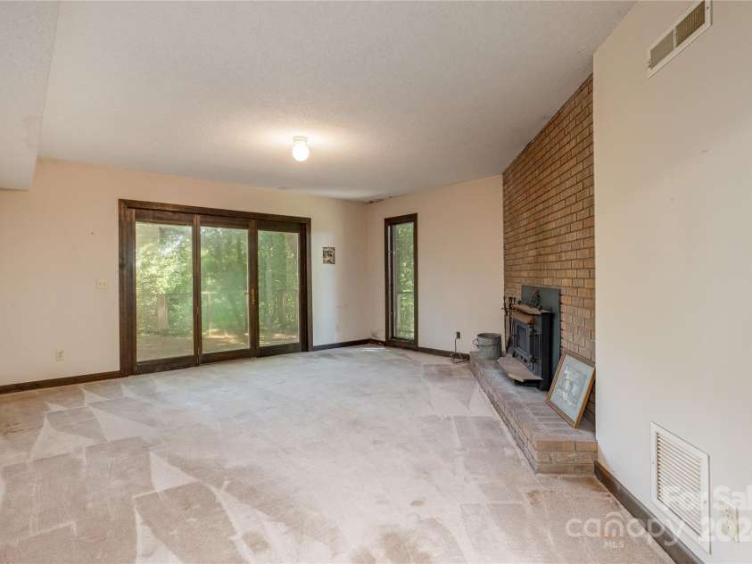 120 Pinewood Circle, Laurel Park, NC 28739.  MLS# CAR4187518, YatesRealty ID 7811. Lower Level Family Room with wood stove
