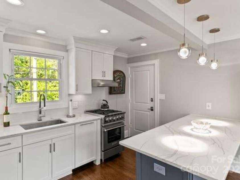 241 Wakefield Drive, Charlotte, NC 28209.  MLS# CAR4248262, YatesRealty ID 7816. Kitchen Opens to the living room with a wide designed Island for eating and storage. High end custom pendant lights add to the custom look