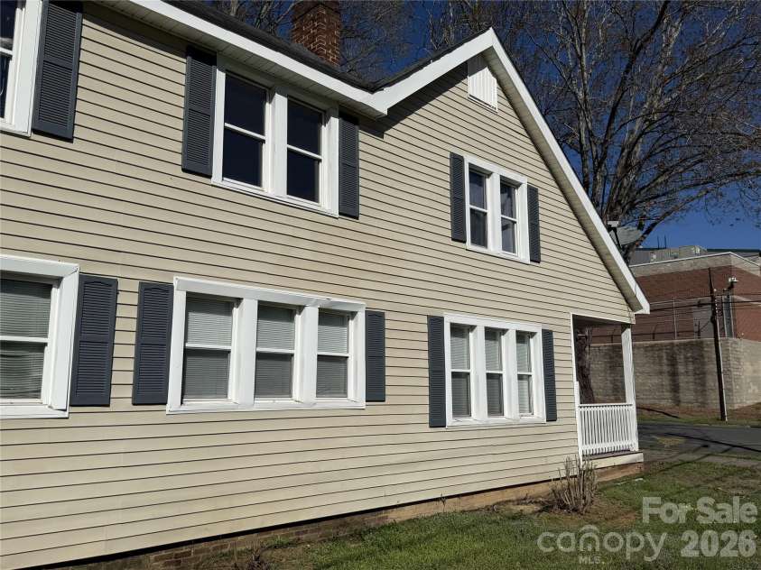 208 3rd Street, Albemarle, NC 28001.  MLS# CAR4358248, YatesRealty ID 7833. Clean side exterior with shutters and brick foundation — solid, low-maintenance shell that protects your investment for decades with almost no upkeep.