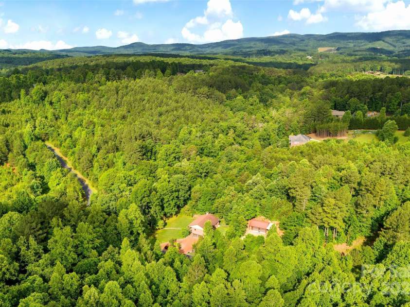967 Clear Water Drive, Nebo, NC 28761.  MLS# CAR4147969, YatesRealty ID 7868. Aerial of the house and garage and the mountains beyond.