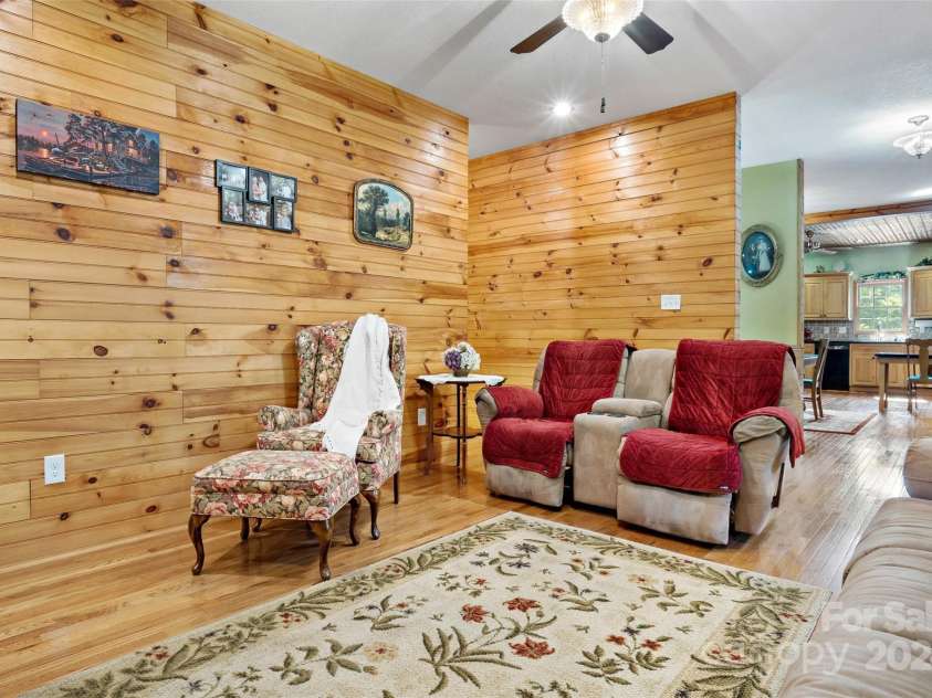 967 Clear Water Drive, Nebo, NC 28761.  MLS# CAR4147969, YatesRealty ID 7868. The living room view from beside the fireplace, for gazing, reading, or watching. Those oak hardwood floors and tongue-in-groove walls add even more warmth.