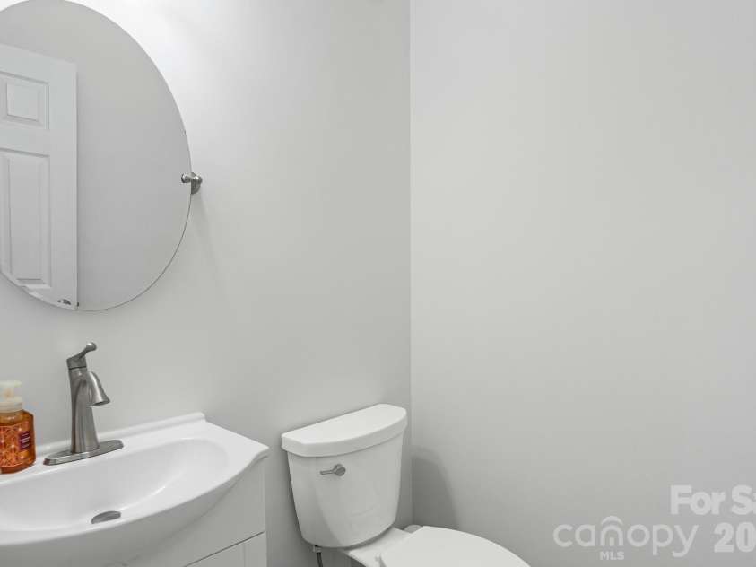 2737 Mill Valley Court, Matthews, NC 28105.  MLS# CAR4394021, YatesRealty ID 7894. Convenient half bath on main level with updated floors, vanity, commode, mirror, and lighting