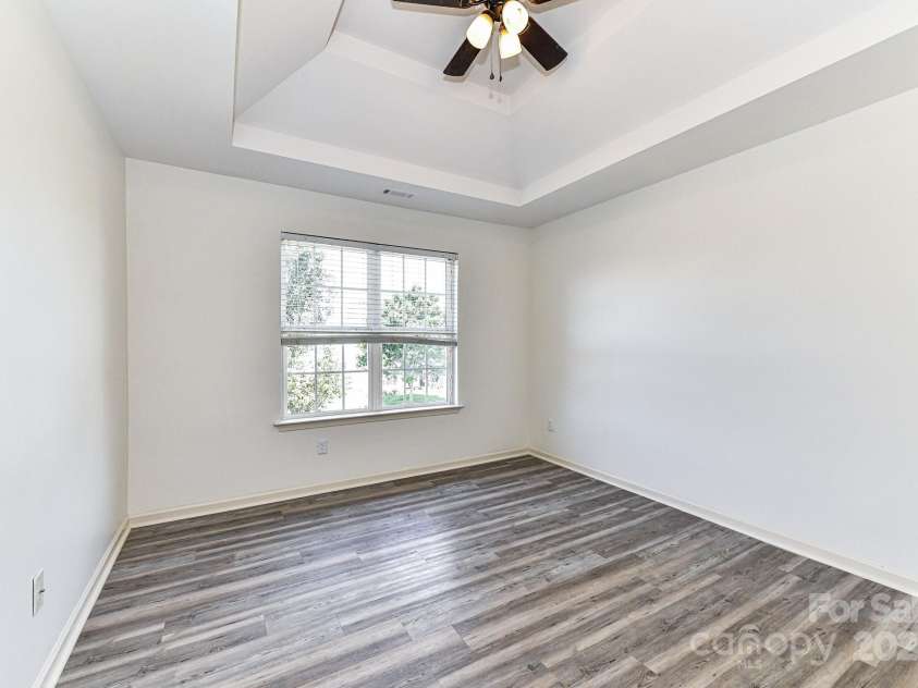 112 Denham Place, Mooresville, NC 28115.  MLS# CAR4237866, YatesRealty ID 7931. Bedroom 2 with double tray ceiling, ceiling fan/light & LVP floors!
