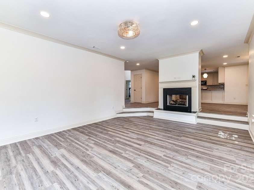 112 Denham Place, Mooresville, NC 28115.  MLS# CAR4237866, YatesRealty ID 7931. Sunken Great Room offers custom light fixture, recessed lights, double sided, gas fireplace & LVP!