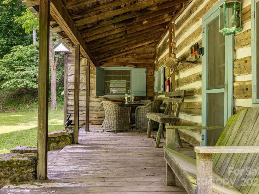 2395 Hortons Creek Road, Burnsville, NC 28714.  MLS# CAR4219244, YatesRealty ID 7959. A large covered porch perfect for relaxing and chatting