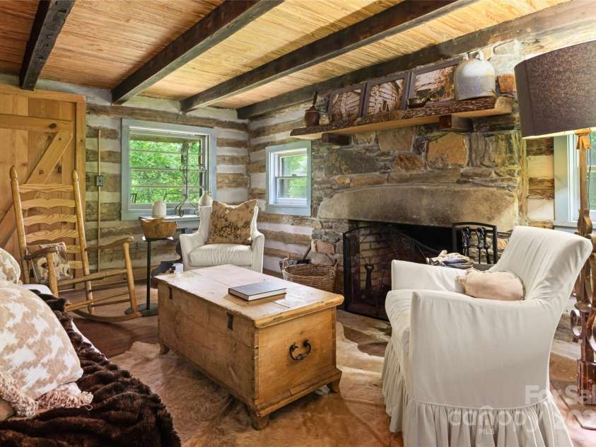 2395 Hortons Creek Road, Burnsville, NC 28714.  MLS# CAR4219244, YatesRealty ID 7959. Entrance to the front side living area - photos of the cabins before being moved to the site on the mantel.