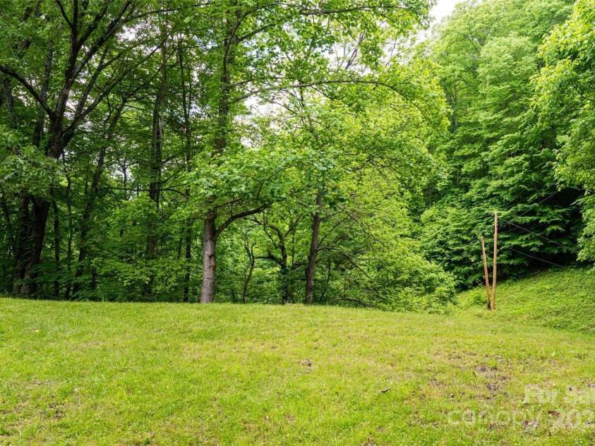 2395 Hortons Creek Road, Burnsville, NC 28714.  MLS# CAR4219244, YatesRealty ID 7959. Set up your corn hole or horseshoe pit in the side yard.