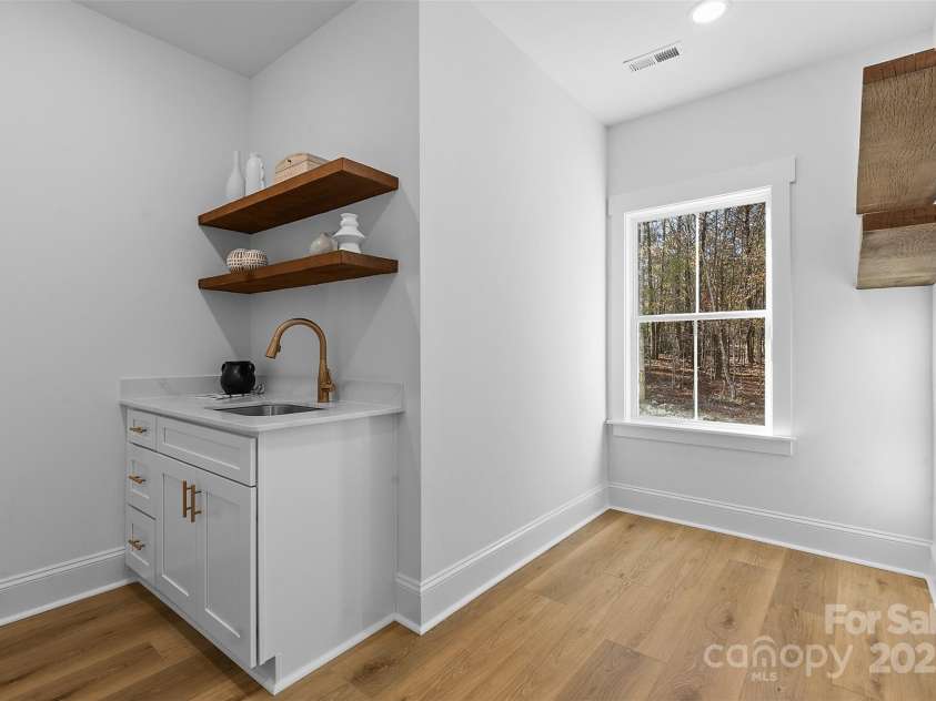 4734 Polk Ford Road, Stanfield, NC 28163.  MLS# CAR4321692, YatesRealty ID 7971. *representative photo- laundry room/mud room w/ extra storage, laundry sink, and wood shelving
