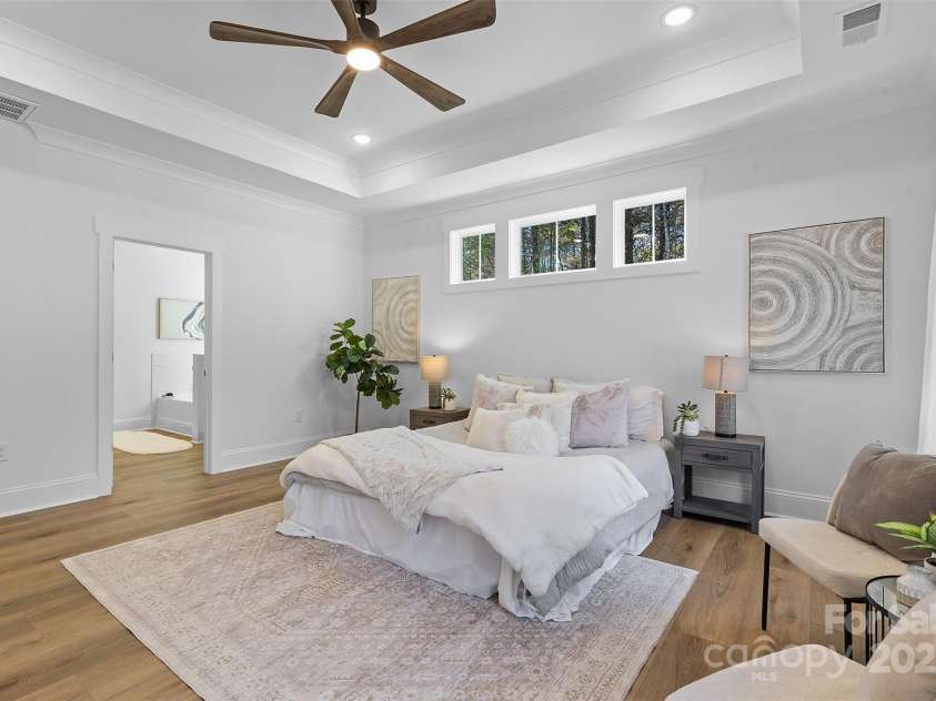 4734 Polk Ford Road, Stanfield, NC 28163.  MLS# CAR4321692, YatesRealty ID 7971. *representative photo- primary bedroom w/ tray ceiling, additional windows for natural light, ensuite bathroom, and a private access to the covered back porch!