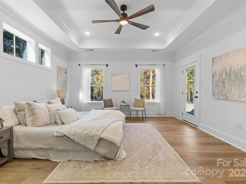 4734 Polk Ford Road, Stanfield, NC 28163.  MLS# CAR4321692, YatesRealty ID 7971. *representative photo- primary bedroom w/ tray ceiling, additional windows for natural light, ensuite bathroom, and a private access to the covered back porch!