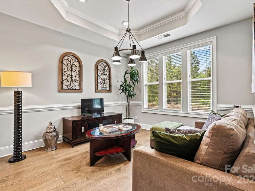 7549 Short Putt Court, Charlotte, NC 28215.  MLS# CAR4248938, YatesRealty ID 8028. Currently used as a Sitting Room/Den, the Dining Room features a stunning tray ceiling that draws your eye upward to the updated fixture, while natural light floods in and the wood floors shine.