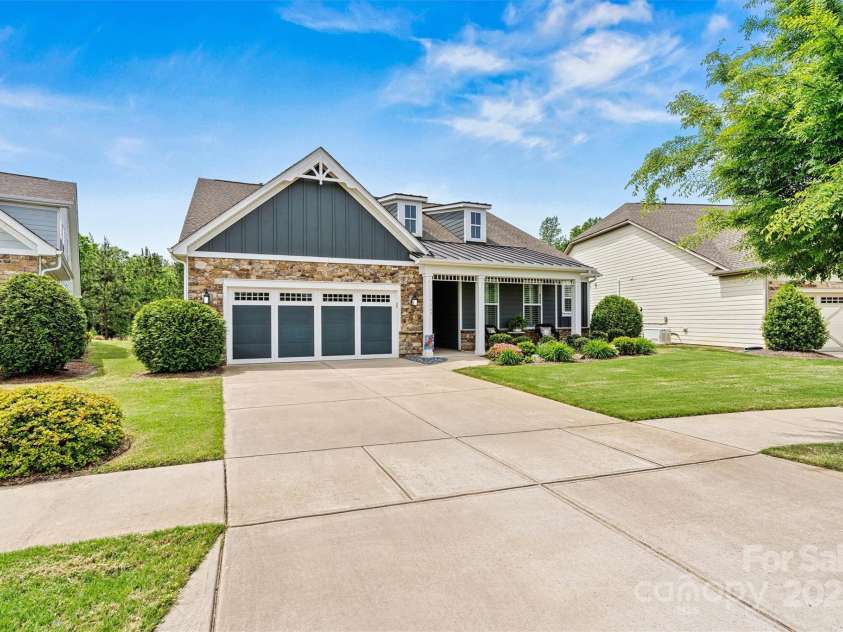 7549 Short Putt Court, Charlotte, NC 28215.  MLS# CAR4248938, YatesRealty ID 8028. Talk about curb appeal! Stone accents, sleek metal roof details, and classic board & batten siding elevate this beauty on a premium homesite.