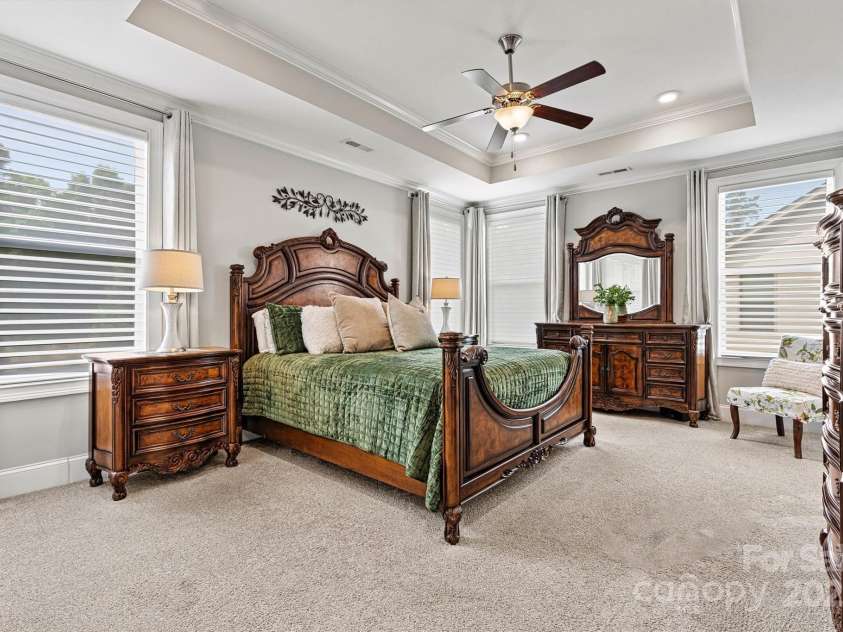 7549 Short Putt Court, Charlotte, NC 28215.  MLS# CAR4248938, YatesRealty ID 8028. The calming tones, Silhouette blinds, and tray ceiling create the perfect ambiance, while large windows flood the room with natural light, making this Primary Suite feel bright and airy.