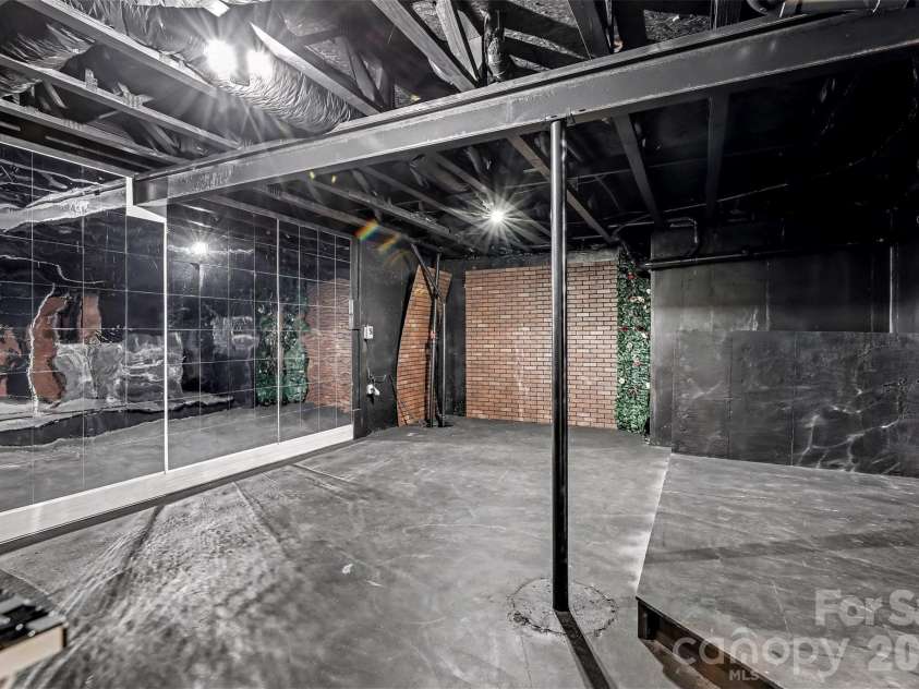 2326 Donnington Lane, Concord, NC 28027.  MLS# CAR4356967, YatesRealty ID 8071. This basement flex space has been transformed into a vibrant entertainment room, radiating a fun, quirky, and limitless sense of possibility. The area boasts a versatile design, making it the perfect haven for relaxation