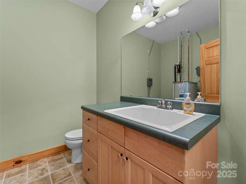 1299 Pine Ridge Road, Burnsville, NC 28714.  MLS# CAR4306270, YatesRealty ID 8091. Multi-purpose room that serves as a half bath and utility room with a deep utility sink