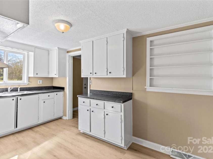 216 Georgia Avenue, Bessemer City, NC 28016.  MLS# CAR4240222, YatesRealty ID 8098. Kitchen with White Cabinets, Shelves for open storage