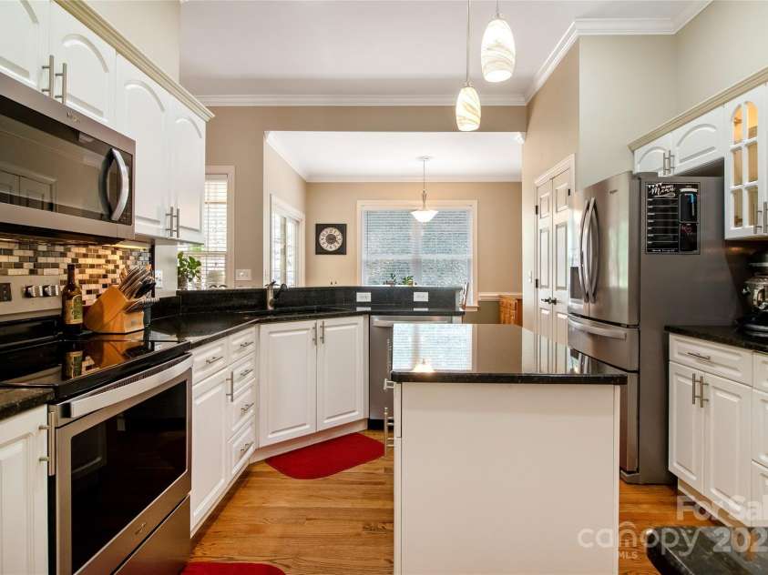 74 Old Logging Trail, Hendersonville, NC 28739.  MLS# CAR4241041, YatesRealty ID 8136. Classic black and white kitchen with warm wood floors