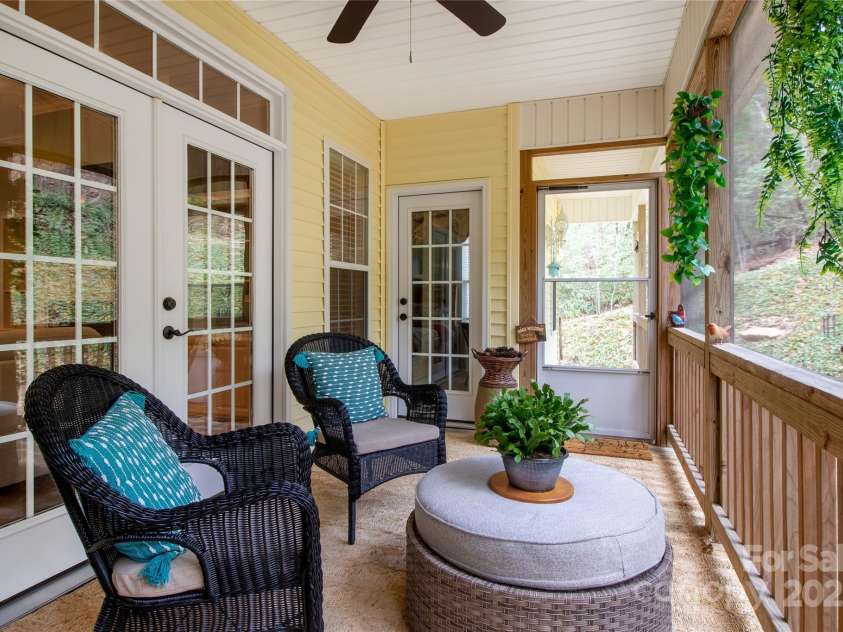 74 Old Logging Trail, Hendersonville, NC 28739.  MLS# CAR4241041, YatesRealty ID 8136. Comfy screened porch opens onto patio with hot tub and grill area
