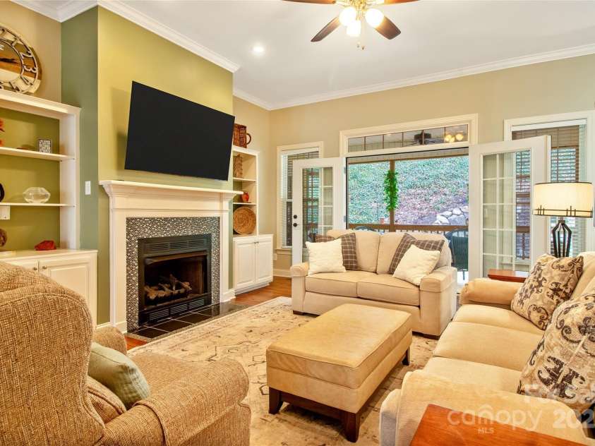 74 Old Logging Trail, Hendersonville, NC 28739.  MLS# CAR4241041, YatesRealty ID 8136. Living area with gas fireplace opens onto screened porch