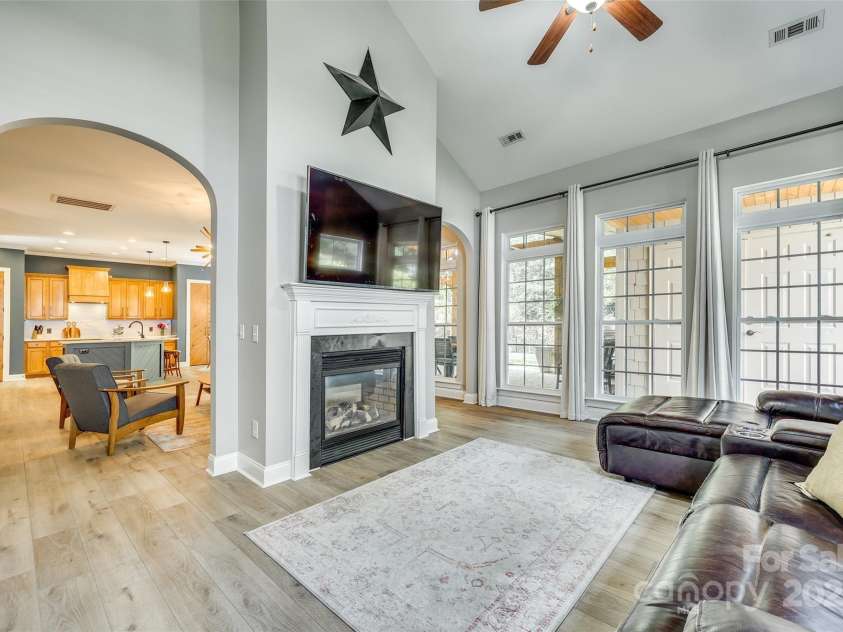 349 Miners Cove Way, Fort Mill, SC 29708.  MLS# CAR4248883, YatesRealty ID 8213. The architectural centerpiece of this exceptional home is a stunning see-through fireplace that creates a sophisticated connection between the welcoming great room and the light-filled sunroom.