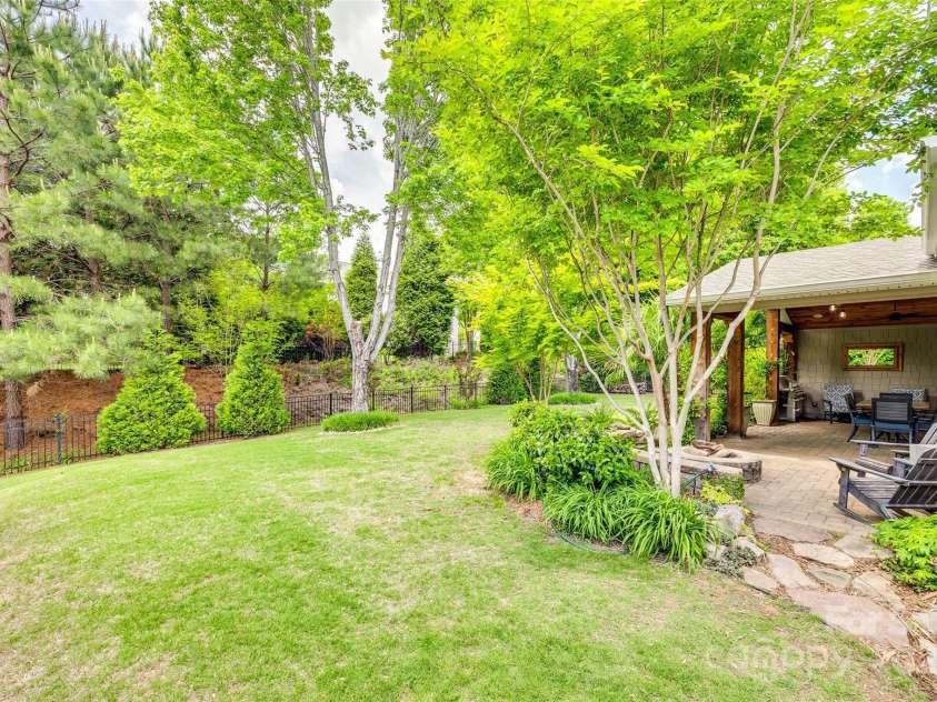 349 Miners Cove Way, Fort Mill, SC 29708.  MLS# CAR4248883, YatesRealty ID 8213. This charming back yard is fully fenced, providing a secure and private outdoor space ideal for relaxation and recreation. The yard offers ample room for various activities, from enjoying a morning coffee to hosting sum