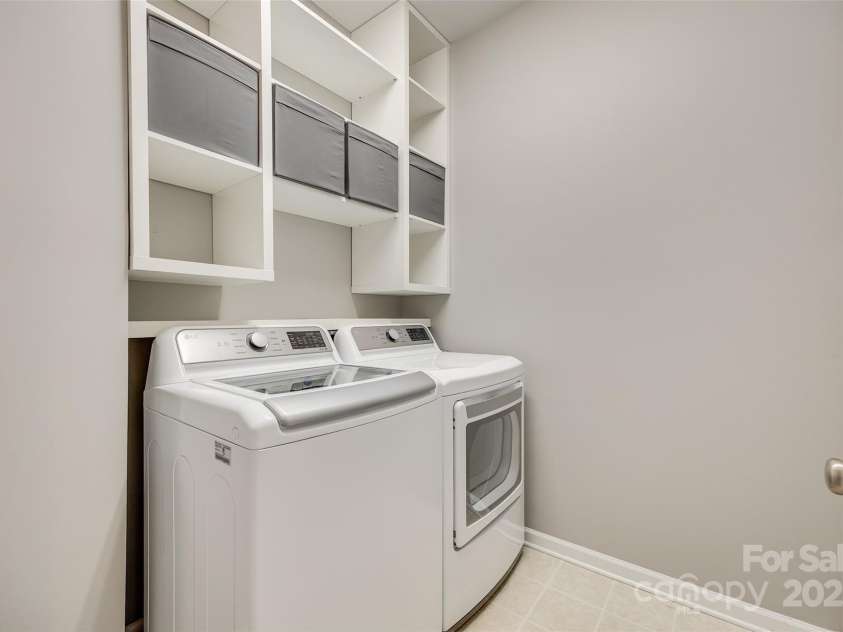 349 Miners Cove Way, Fort Mill, SC 29708.  MLS# CAR4248883, YatesRealty ID 8213. This spacious laundry room offers a convenient and efficient space for all your laundry needs. Located conveniently on the second floor, it eliminates the need to carry heavy laundry baskets up and down stairs, saving y