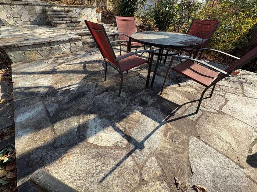 114 Broadway Avenue, Tryon, NC 28782.  MLS# CAR4322856, YatesRealty ID 823. Stone terraces in the back yard are perfect for entertaining.