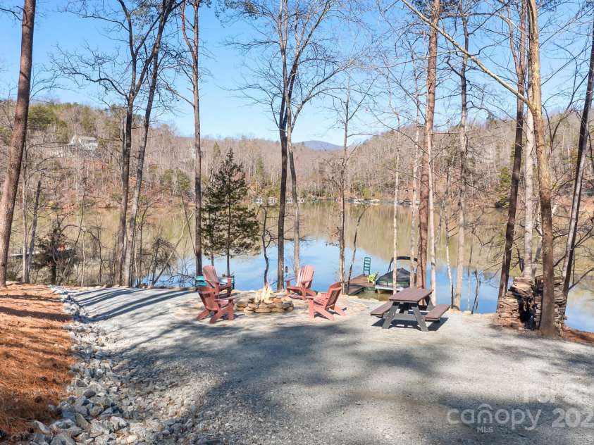 940 Hawk Ridge Drive, Mill Spring, NC 28756.  MLS# CAR4227450, YatesRealty ID 8244. Enjoy evening around the firepit and stone patio overlooking Lake Adger.  This serene lake front property is perfect for entertaining family and guests.