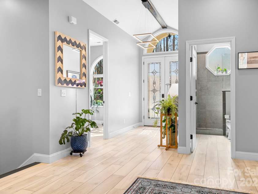 940 Hawk Ridge Drive, Mill Spring, NC 28756.  MLS# CAR4227450, YatesRealty ID 8244. Foyer entrance space with Stain Glass insert double doors, Arched windows, and Modern design elements.
