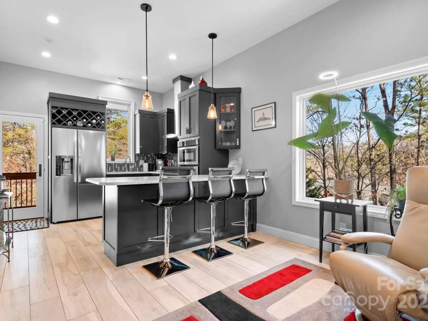 940 Hawk Ridge Drive, Mill Spring, NC 28756.  MLS# CAR4227450, YatesRealty ID 8244. Second Kitchen on main living perfect for guests,in -law suite, or many other uses! Modern and coordinates with primary kitchen.  Small den area and door to covered screened deck area too.  2nd primary suite tor the 