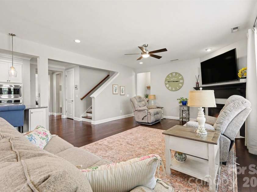 174 Country Lake Drive, Mooresville, NC 28115.  MLS# CAR4361802, YatesRealty ID 8293. Family room is open to the kitchen and breakfast dining area. The downstairs main is accessed behind the chair by the clock, perfect for overnight guests or multi generational living.