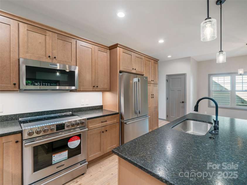 100 Red Twig Lane, Burnsville, NC 28714.  MLS# CAR4155743, YatesRealty ID 8313. Counter height Island with with undermount sink and Stainless steel Appliances  and soft close drawes and cabinets, Microwave with built in Air Fryer