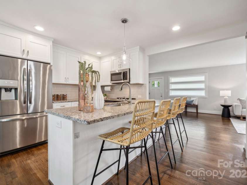 3725 Dunwoody Drive, Charlotte, NC 28215.  MLS# CAR4245588, YatesRealty ID 8389. The bright, updated kitchen comes complete with a bar area, granite countertops, and SS appliances.