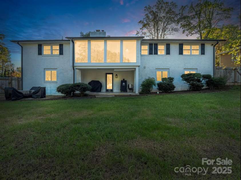 2115 Stoney View Court, Hendersonville, NC 28792.  MLS# CAR4310001, YatesRealty ID 839. Beautiful twilight view showcasing the home’s inviting glow and spacious backyard