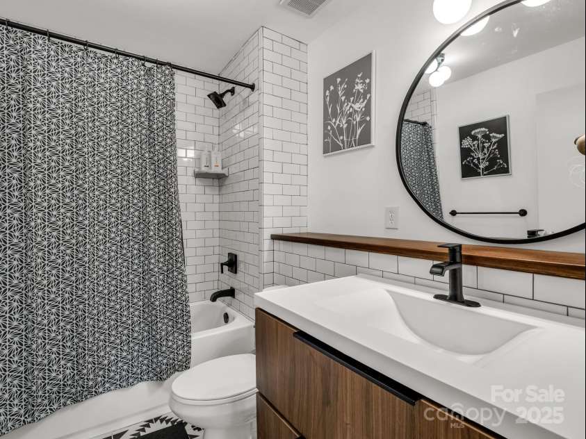 2115 Stoney View Court, Hendersonville, NC 28792.  MLS# CAR4310001, YatesRealty ID 839. Beautifully updated bathroom featuring sleek black fixtures, subway tile, and a stylish floating vanity for a clean, modern look