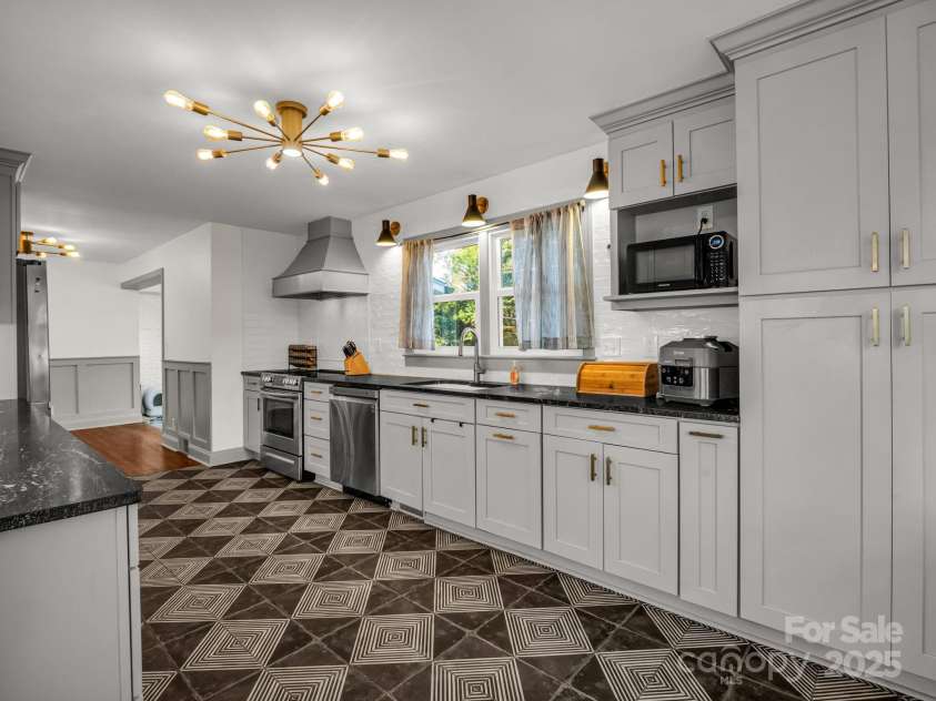 2115 Stoney View Court, Hendersonville, NC 28792.  MLS# CAR4310001, YatesRealty ID 839. Stylish and spacious kitchen featuring modern lighting, sleek stainless steel appliances, and custom cabinetry with gold accents