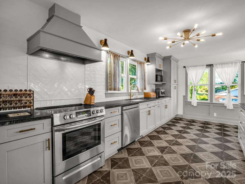 2115 Stoney View Court, Hendersonville, NC 28792.  MLS# CAR4310001, YatesRealty ID 839. Stylish and spacious kitchen featuring modern lighting, sleek stainless steel appliances, and custom cabinetry with gold accents