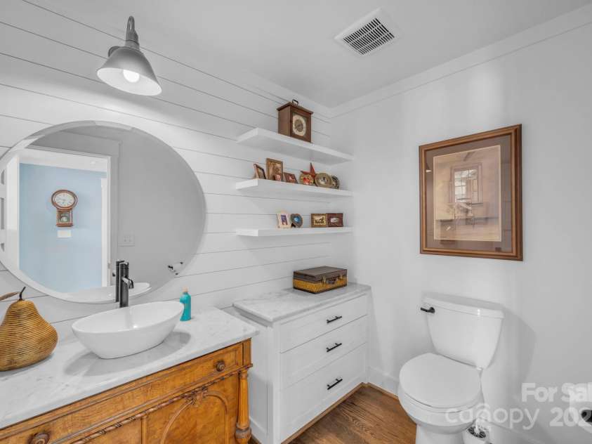 1260 Beaver Island Trail Road, Walnut Cove, NC 27052.  MLS# CAR4325171, YatesRealty ID 843. Main floor powder room w/ vessel sink and quartz countertop, 3 floating decorative shelves, and built in storage cabinet w/ quartz countertop