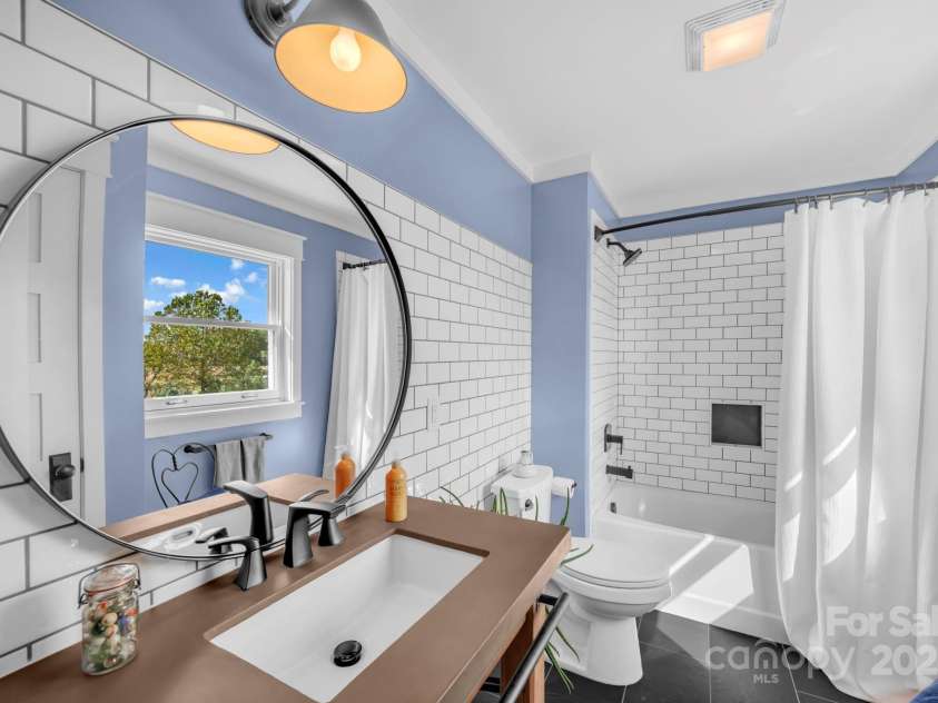 1260 Beaver Island Trail Road, Walnut Cove, NC 27052.  MLS# CAR4325171, YatesRealty ID 843. Second floor full bathroom with concrete countertop, backsplash accent wall, Pfister sink, black accent tile floor, and tub/shower combo w/ tile surround