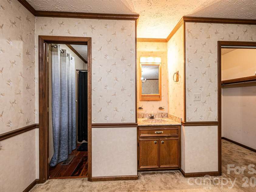 7141 Knobs Landing, Connelly Springs, NC 28612.  MLS# CAR4353694, YatesRealty ID 8442. Primary Bedroom with attached partial bath, vanity with sink, and walk in closet