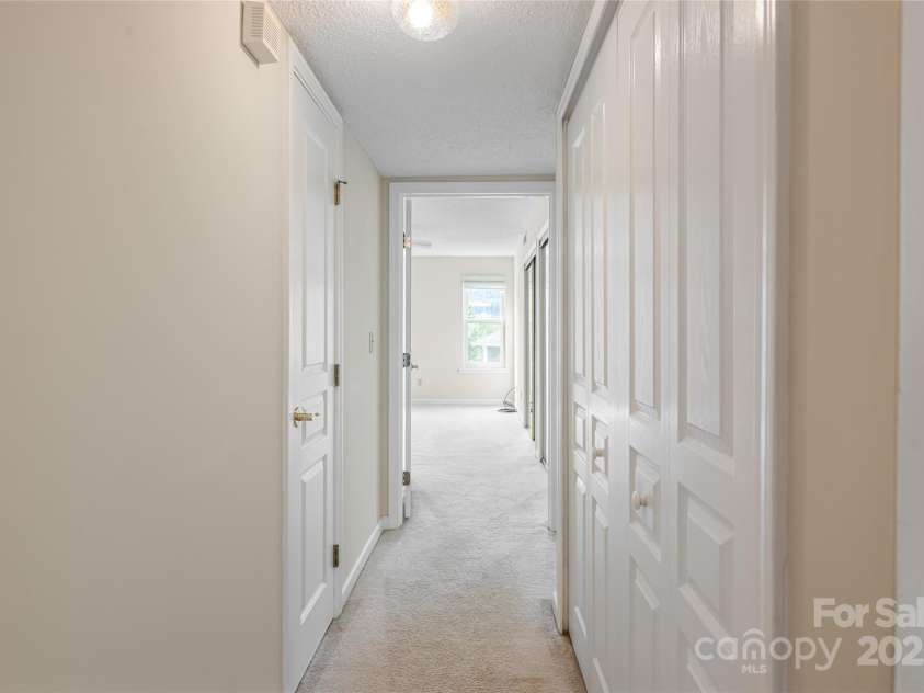 4805 Breakers Lane, Asheville, NC 28806.  MLS# CAR4307390, YatesRealty ID 848. Hallway to primary bedroom, guest room, main bath and laundry closet. 