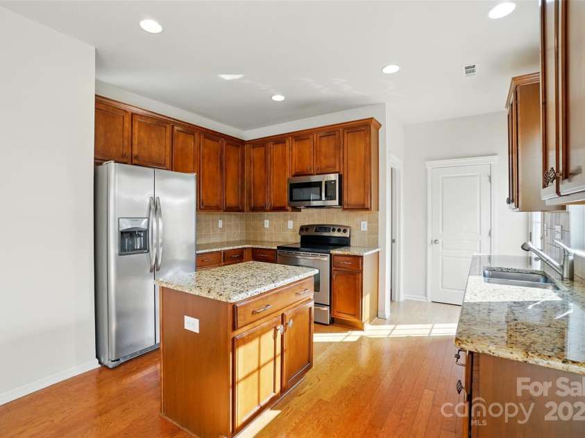 3619 Grove Creek Pond Drive, Concord, NC 28027.  MLS# CAR4244273, YatesRealty ID 8492. Kitchen with center island, granite counters, stainless appliances and wood floors!