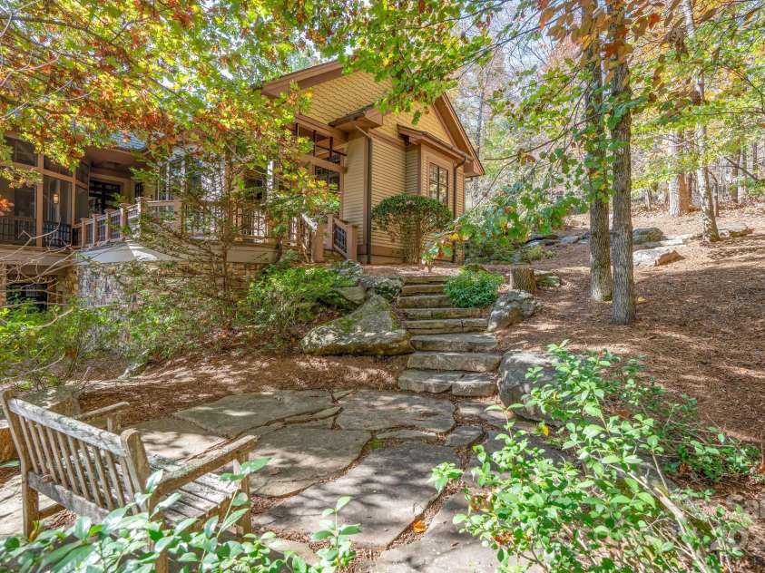 150 Cherry Hill, Mill Spring, NC 28756.  MLS# CAR4201746, YatesRealty ID 8524. Stone steps lead down to a serene sitting area - the hardscape design and extensive stone work at this home is a wonderful addition to the wooded setting.