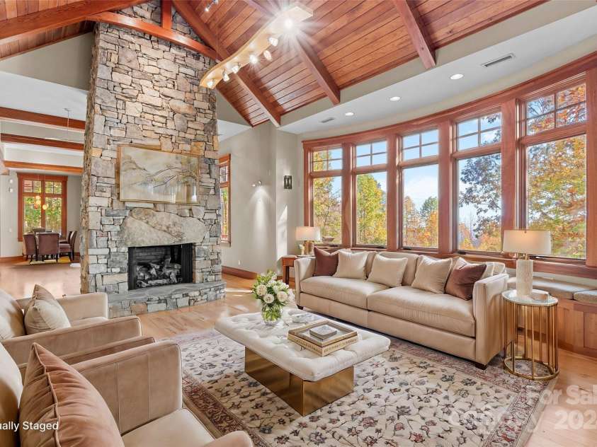 150 Cherry Hill, Mill Spring, NC 28756.  MLS# CAR4201746, YatesRealty ID 8524. The living room has a curved wall of windows looking out over the long range views. There is even a cozy breakfast area at the other end of this open concept living space.