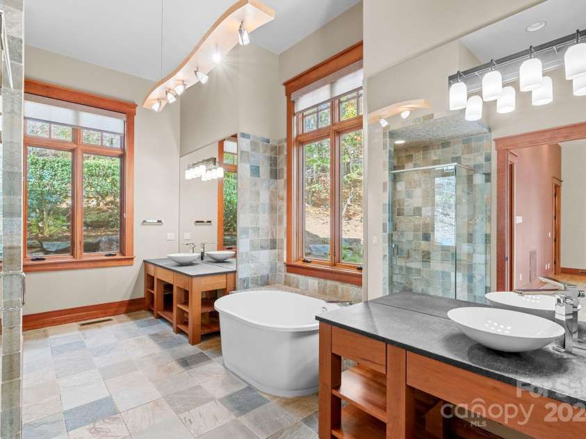 150 Cherry Hill, Mill Spring, NC 28756.  MLS# CAR4201746, YatesRealty ID 8524. The primary bathroom is sure to please with separate vanity areas and garden tub in addition to a spacious tiled shower.