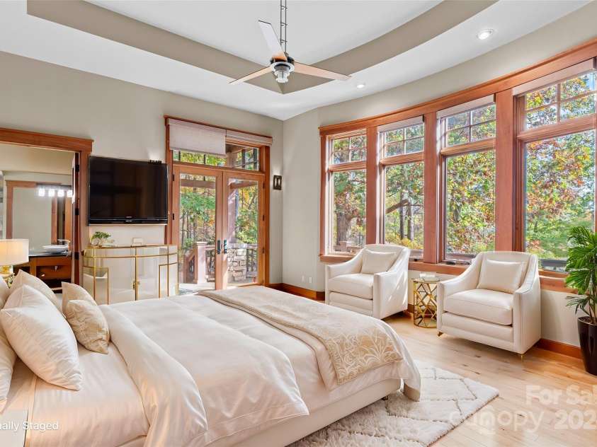 150 Cherry Hill, Mill Spring, NC 28756.  MLS# CAR4201746, YatesRealty ID 8524. Wonderful primary bedroom with two huge walk in closets, en suite full bath with high quality finishes, plus big views from the wall of windows.